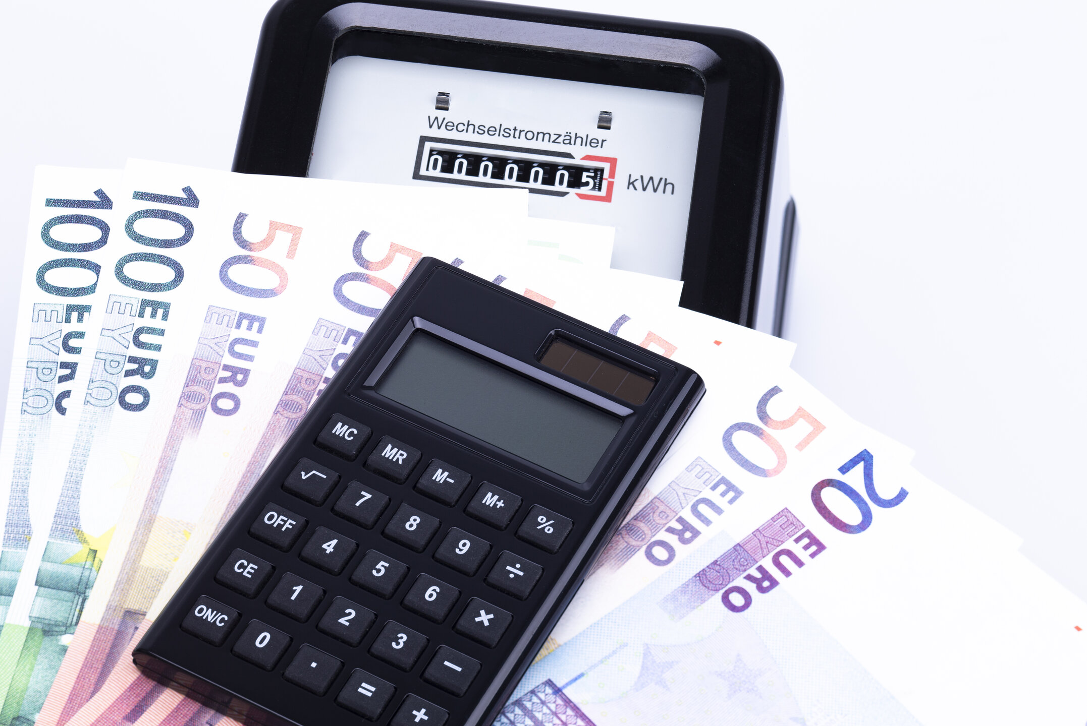 Stromzähler, Geldscheine und ein Taschenrechner