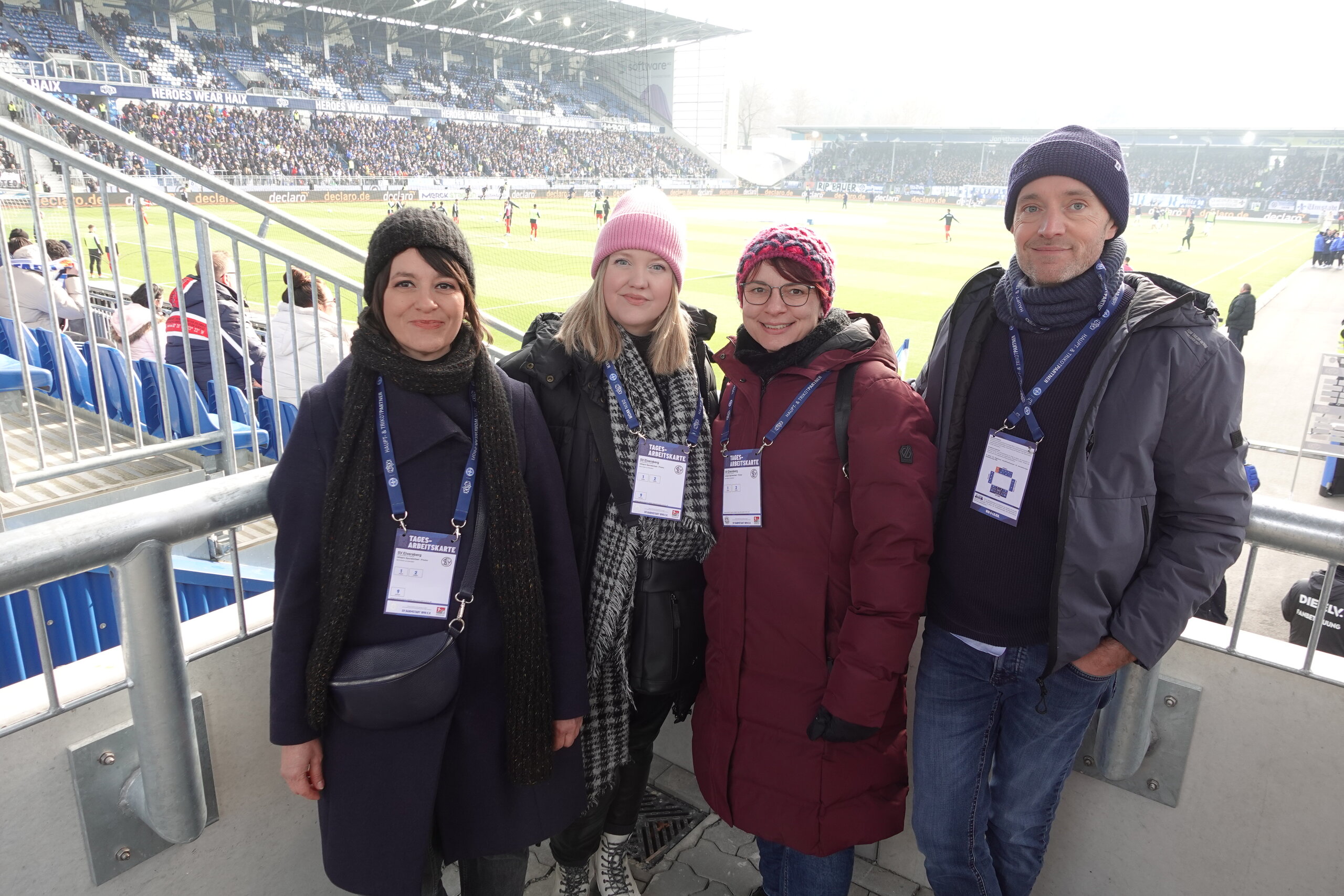 vier Personen in einem Fußballstadion