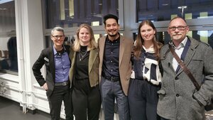 Abbildung fünf Personen vor einem Fenster