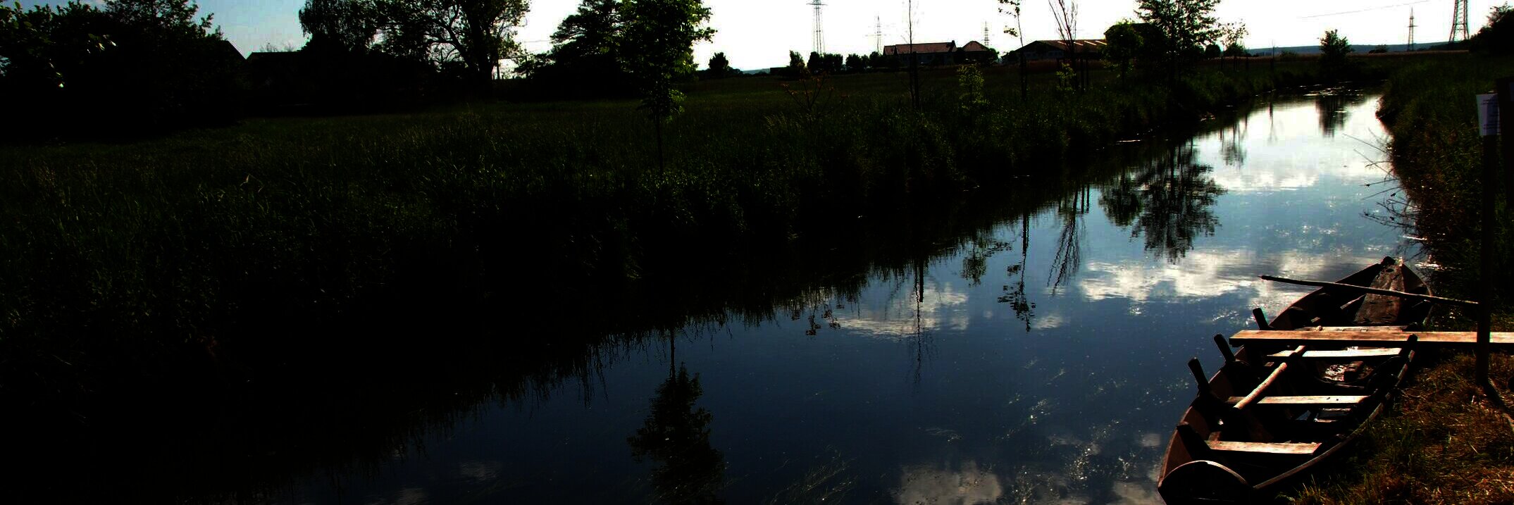 Landschaftsaufnahme mit einem Kanal und einem kleinen Boot